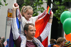 Foto eines Mannes mit Kind und Regenbogenflagge